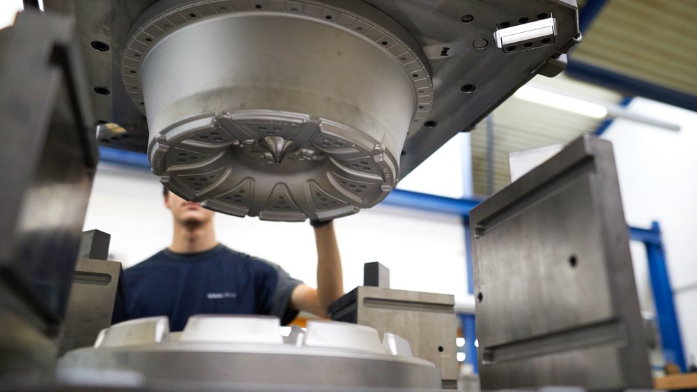 a man standing behind a Ronal Smart Casting machine