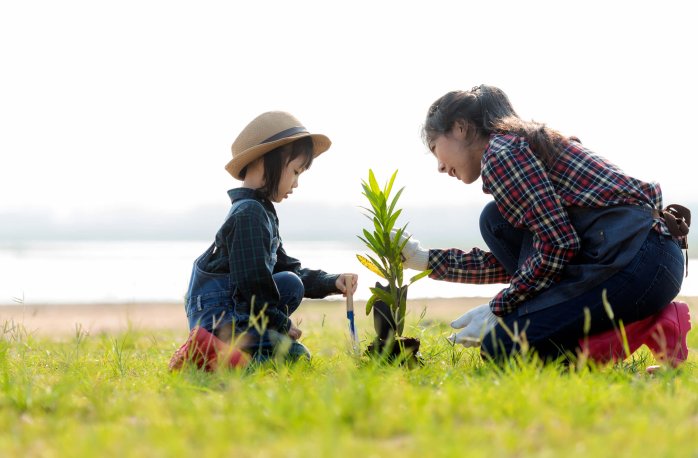 A child and a woman planting a tree